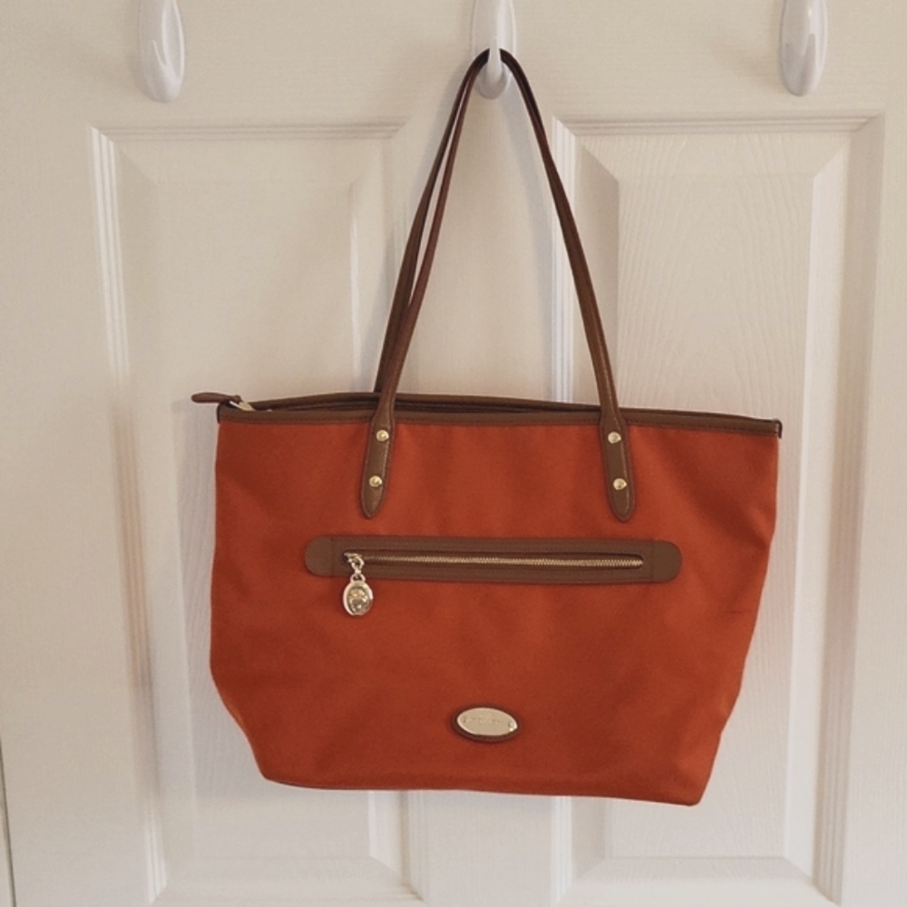 Coach zip bag with gold/tan accents, dark orange primary color